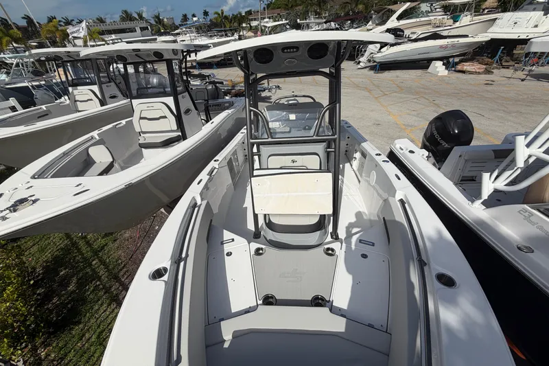 Slide: The Image of 2026 Sea Pro 225FLX Sandbar boat, sleek design, docked among other boats. - 9