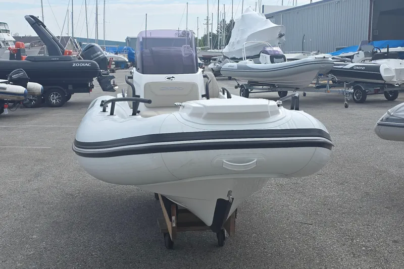 Slide: The Image of 2027 Grand Inflatables G420 boat displayed in a marina with other vessels. - 1