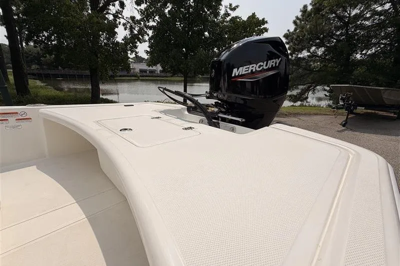 Slide: The Image of 2026 Mako Pro Skiff 17 CC boat with Mercury engine by a lakeside. - 13