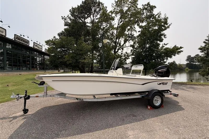 The Image of 2026 Mako Pro Skiff 17 CC boat on trailer, parked near a lake. - 0