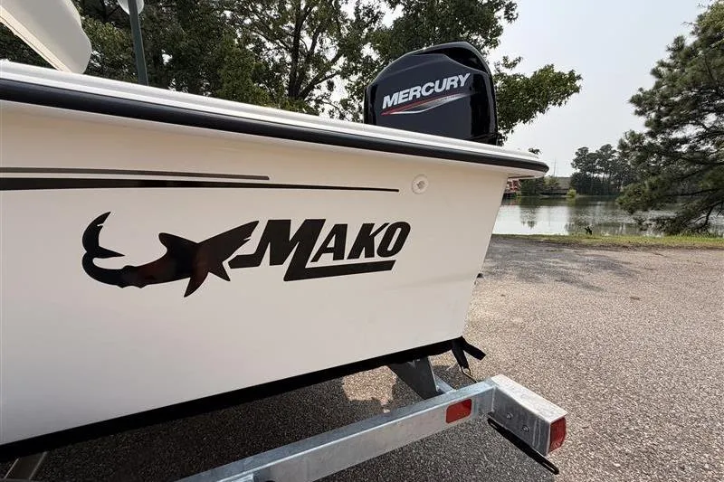 Slide: The Image of 2026 Mako Pro Skiff 17 CC boat with Mercury engine by a lake. - 15