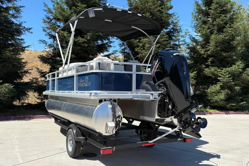 Slide: The Image of 2026 Sun Tracker Bass Buggy 18 DLX pontoon boat on trailer, parked outdoors. - 8