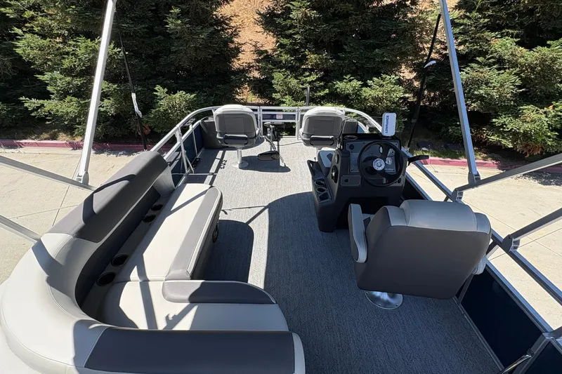 Slide: The Image of 2026 Sun Tracker Bass Buggy 18 DLX pontoon boat interior with seating and steering console. - 14