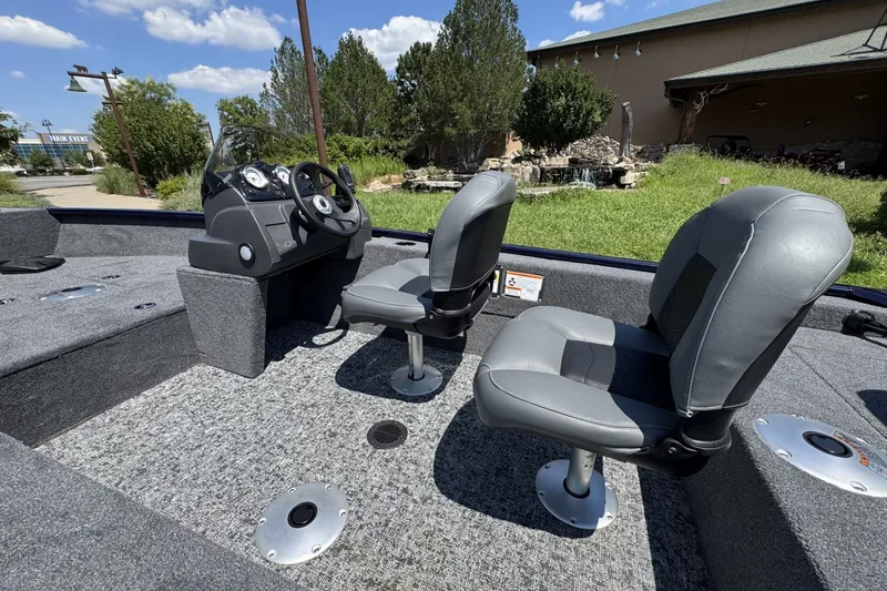Slide: The Image of 2026 Tracker Super Guide V-16 SC boat interior with two gray seats and steering console. - 55