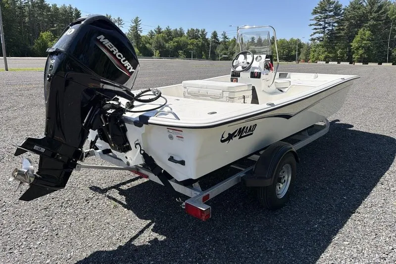 Slide: The Image of 2026 Mako Pro Skiff 17 CC boat on trailer with Mercury engine, parked outdoors. - 4