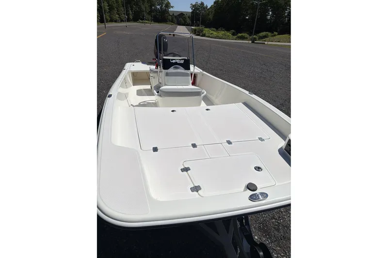 Slide: The Image of 2026 Mako Pro Skiff 17 CC boat on a trailer, parked on a road. - 7