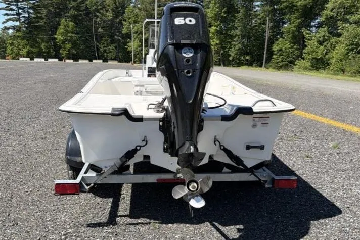 Slide: The Image of 2026 Mako Pro Skiff 17 CC with 60 HP engine on trailer, parked outdoors. - 9