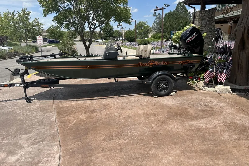 The Image of 2026 Tracker Bass Tracker Classic Limited boat on trailer, parked outdoors with flags. - 0