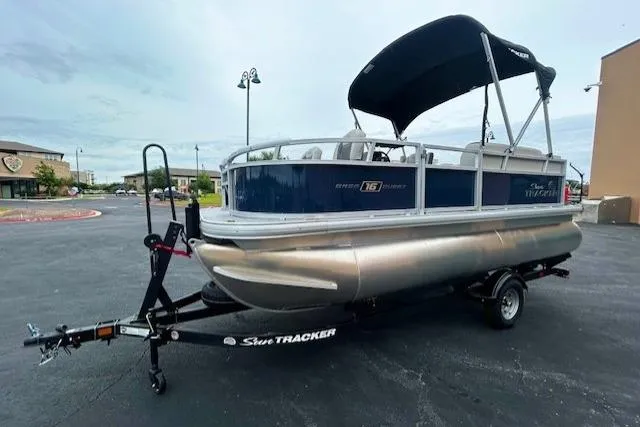 The Image of 2026 Sun Tracker Bass Buggy 18 DLX pontoon boat on trailer, parked outdoors. - 0
