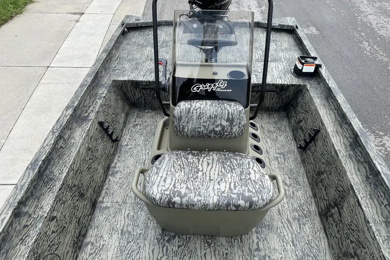 Slide: The Image of 2026 Tracker Grizzly 1860 CC boat with camouflage seating and console on a street. - 17