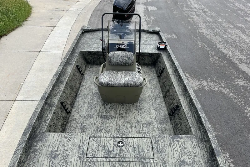 Slide: The Image of 2026 Tracker Grizzly 1860 CC boat with camouflage design on a paved road. - 15