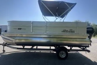 Slide: The Image of 2026 Sun Tracker Party Barge 18 DLX pontoon boat with canopy on trailer. - 2