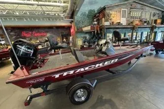 The Image of 2026 Tracker Pro Team 175 boat displayed indoors, featuring a sleek design and Mercury engine. - 0