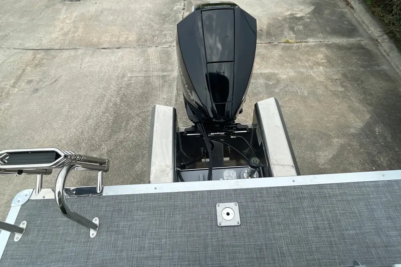 Slide: The Image of 2026 Sun Tracker Party Barge 24 XP3 with powerful outboard motor on concrete surface. - 9