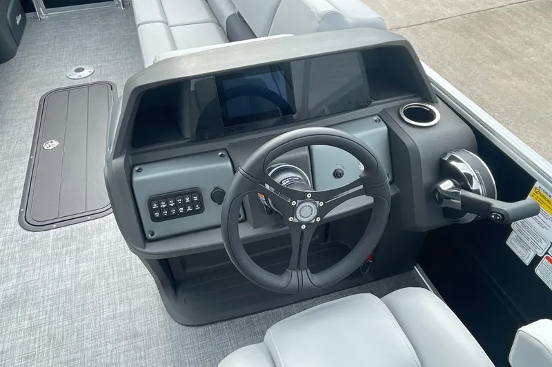 Slide: The Image of 2026 Sun Tracker Party Barge 24 XP3 helm with steering wheel and control panel. - 12