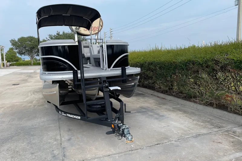 Slide: The Image of 2026 Sun Tracker Party Barge 24 XP3 pontoon boat on trailer, parked outdoors. - 7