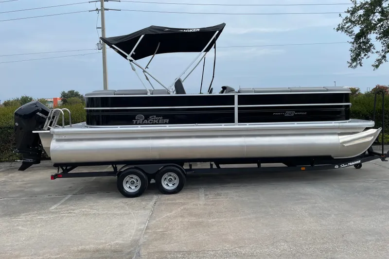 Slide: The Image of 2026 Sun Tracker Party Barge 24 XP3 pontoon boat on trailer, parked outdoors. - 4