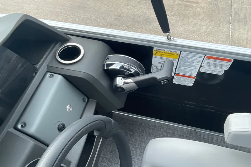 Slide: The Image of 2026 Sun Tracker Party Barge 24 XP3 helm with steering wheel and throttle controls. - 13