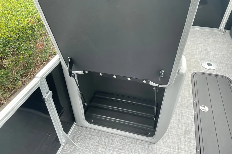Slide: The Image of 2026 Sun Tracker Party Barge 24 XP3 storage compartment with open lid, showcasing interior space. - 24