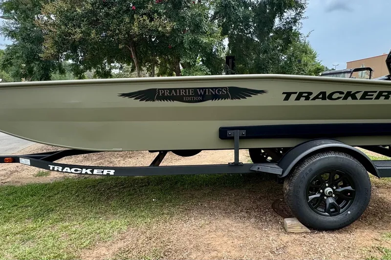The Image of 2026 Tracker Grizzly 1650 T Prairie Wings Edition boat on trailer, parked on grass. - 0