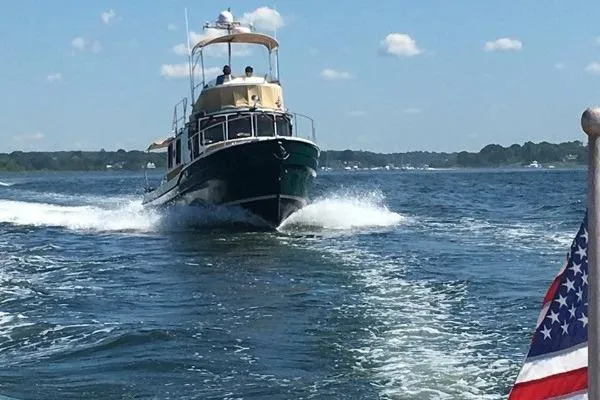 The Image of 2013 Ranger Tugs R-31 CB cruising on open water under a clear blue sky. - 1