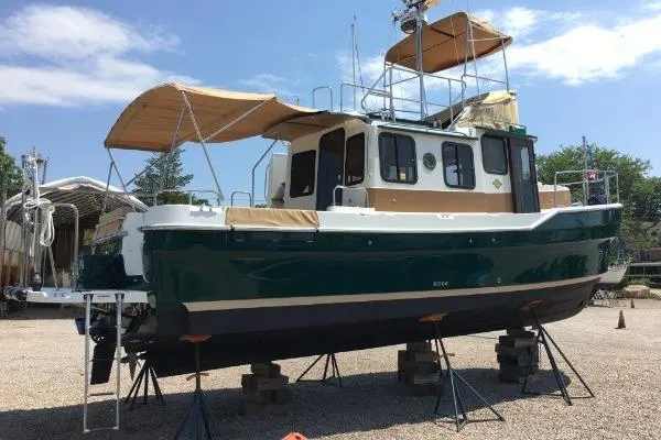 Slide: The Image of 2013 Ranger Tugs R-31 CB boat on stands, green hull, outdoor setting. - 2