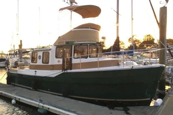 Slide: The Image of 2013 Ranger Tugs R-31 CB docked at sunset, featuring classic design and spacious cabin. - 3