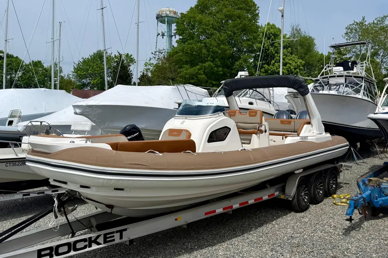 The Image of 2024 Zodiac Medline 9 boat on trailer, surrounded by other boats in a marina. - 0