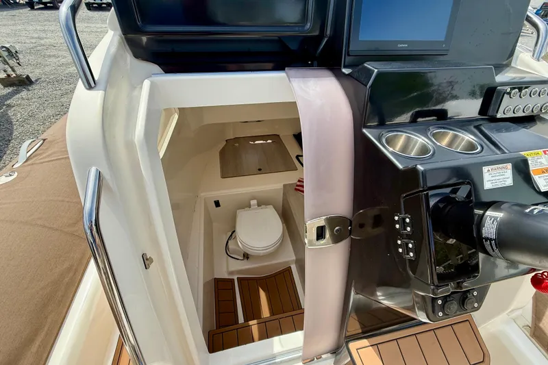 Slide: The Image of 2024 Zodiac Medline 9 boat interior with helm, controls, and cabin toilet. - 14
