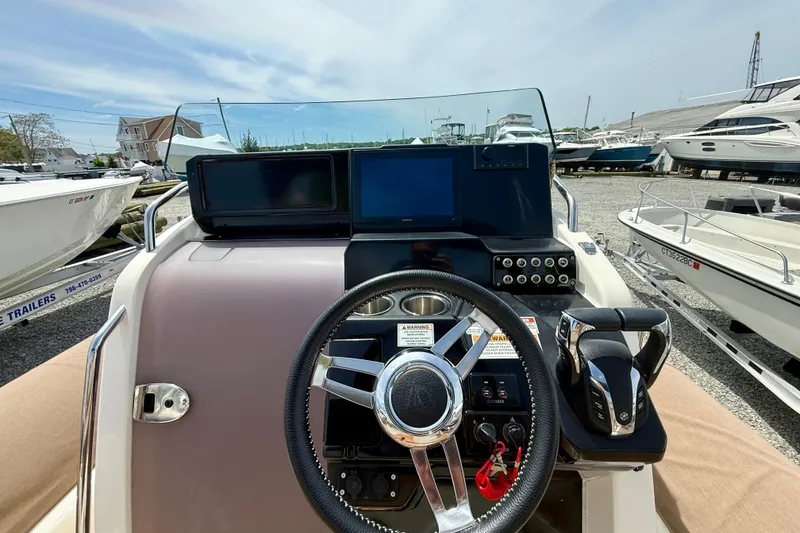 Slide: The Image of 2024 Zodiac Medline 9 boat dashboard with steering wheel and control panel. - 18