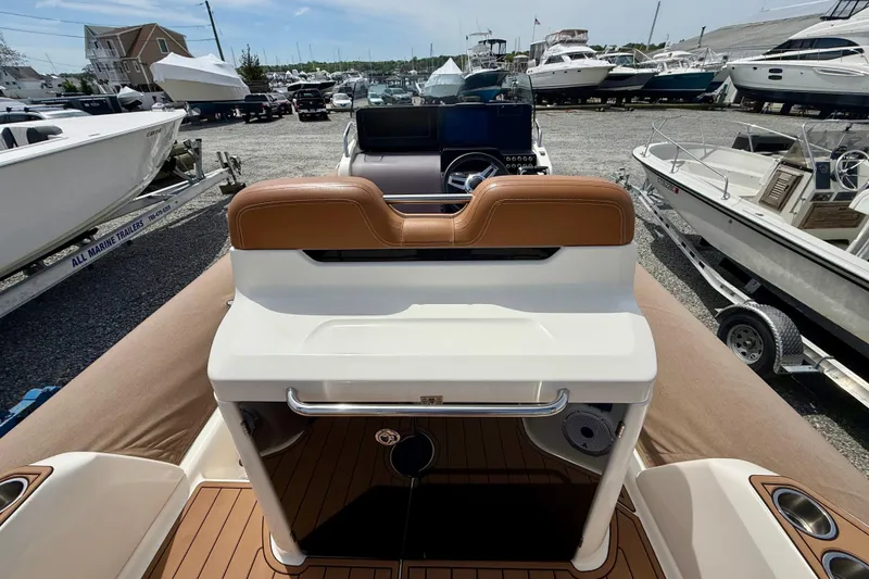 Slide: The Image of 2024 Zodiac Medline 9 boat interior with brown seating, docked among other boats. - 19