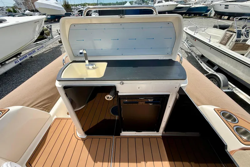 Slide: The Image of 2024 Zodiac Medline 9 boat interior with sink and storage, docked among other boats. - 20