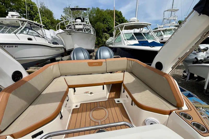 Slide: The Image of 2024 Zodiac Medline 9 boat interior with cushioned seating, docked among other boats. - 21