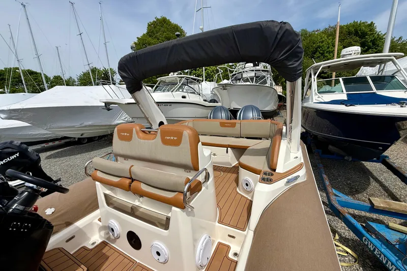 Slide: The Image of 2024 Zodiac Medline 9 boat with luxurious seating and modern design in a marina setting. - 24