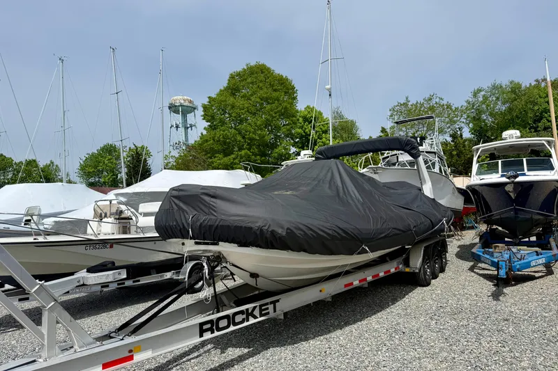 Slide: The Image of 2024 Zodiac Medline 9 boat covered on a trailer, parked in a marina with other boats. - 35
