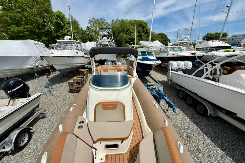 Slide: The Image of 2024 Zodiac Medline 9 boat in a marina, surrounded by other vessels and trailers. - 8