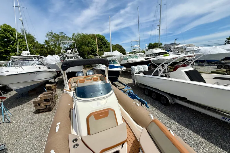 Slide: The Image of 2024 Zodiac Medline 9 boat in a marina with other vessels under a clear sky. - 9