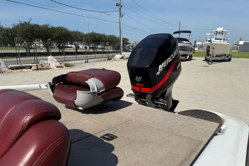 Slide: The Image of 2001 Triton Tr-186 boat with Mercury 150 engine, featuring maroon seats and outdoor setting. - 12
