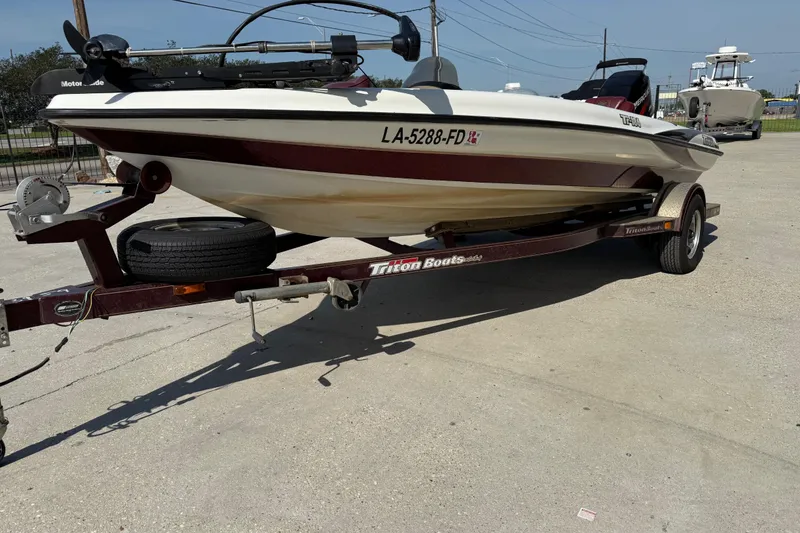 Slide: The Image of 2001 Triton Tr-186 boat on trailer, parked outdoors, with visible registration number. - 15