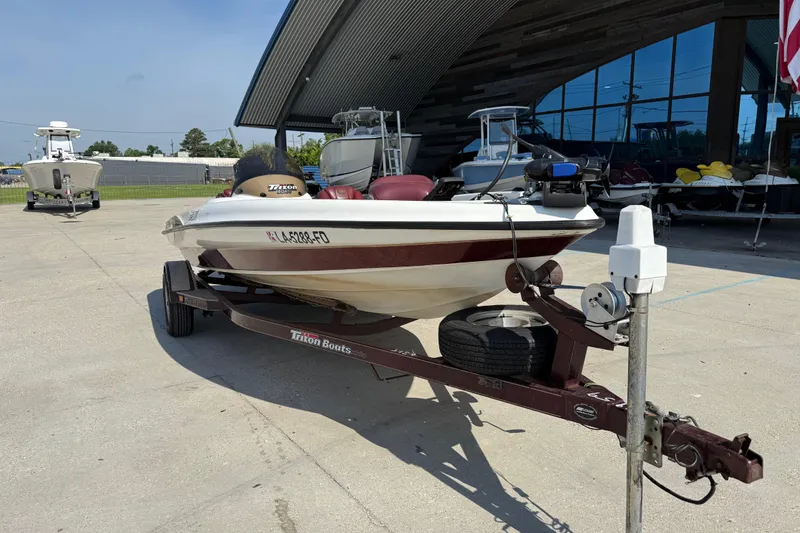 Slide: The Image of 2001 Triton Tr-186 boat on trailer, parked outside a modern building. - 9