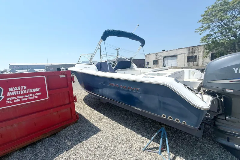 Slide: The Image of 2012 Sea Hunt Escape 250 boat beside red container. - 2