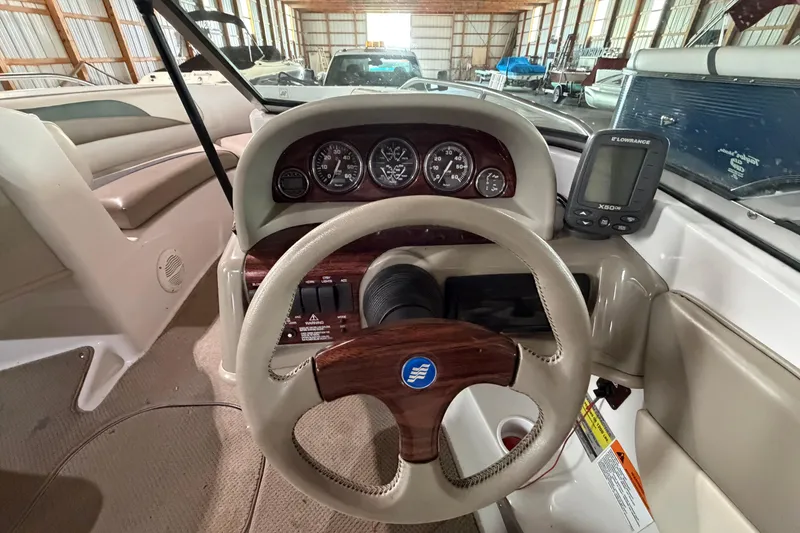 Slide: The Image of 1999 Four Winns 180 Horizon boat dashboard with steering wheel and gauges in storage facility. - 10