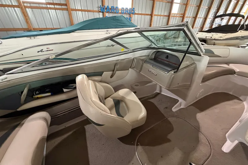 Slide: The Image of 1999 Four Winns 180 Horizon boat interior with beige seating and dashboard in storage. - 13