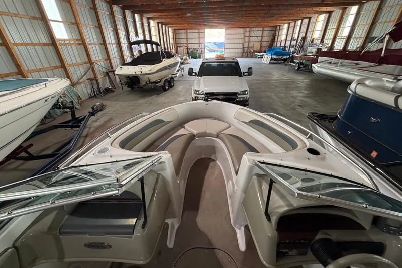 Slide: The Image of 1999 Four Winns 180 Horizon boat in storage, surrounded by other boats and a vehicle. - 14