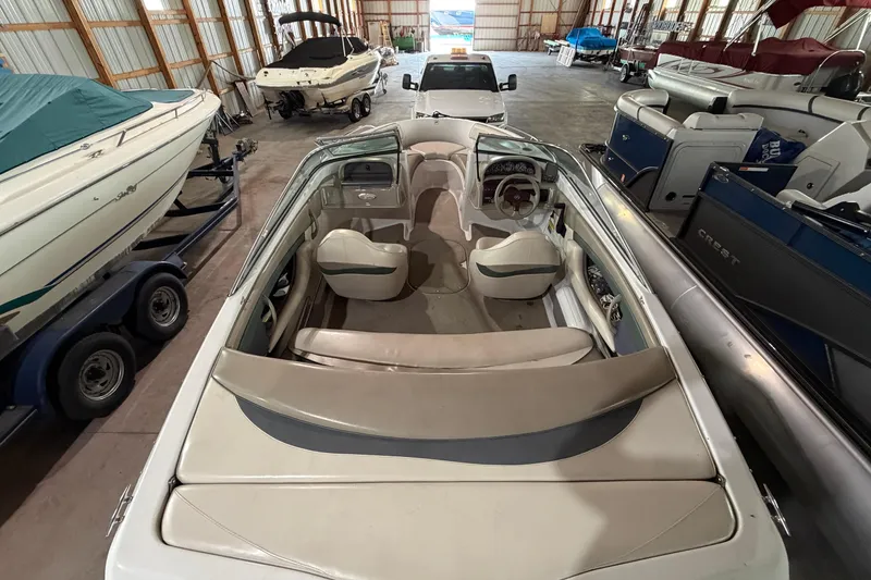 Slide: The Image of 1999 Four Winns 180 Horizon boat interior in storage, surrounded by other boats. - 8