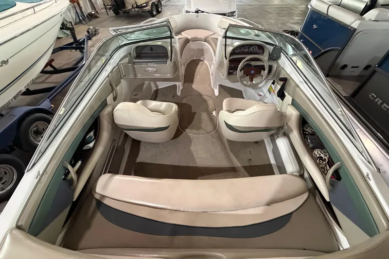 Slide: The Image of Interior view of a 1999 Four Winns 180 Horizon boat, showcasing seating and dashboard. - 9