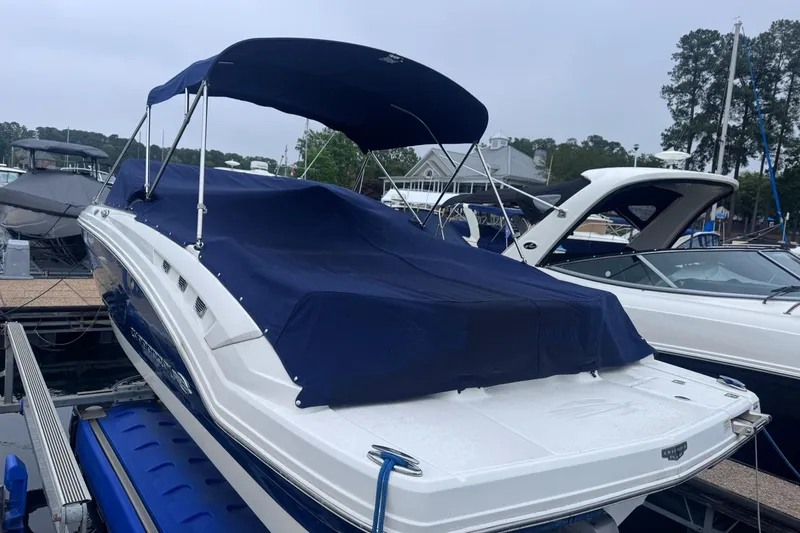 Slide: The Image of 2021 Chaparral 237 SSX boat with blue cover docked at marina. - 3