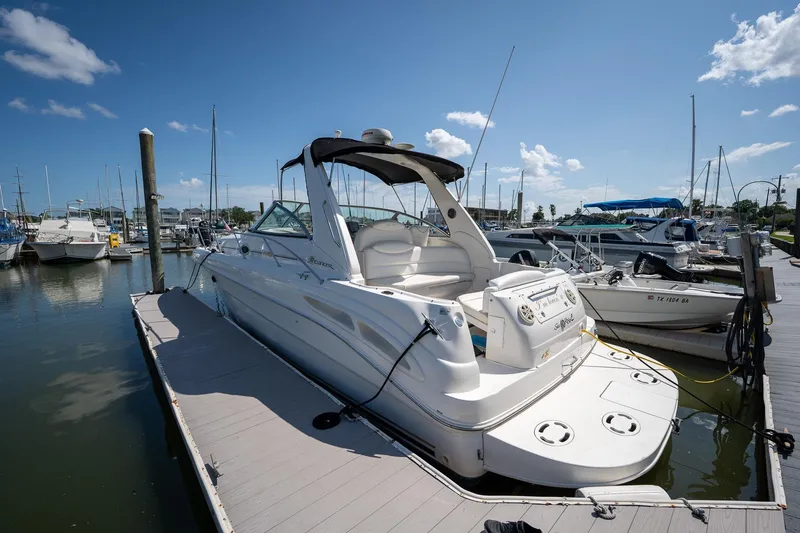The Image of 2000 Sea Ray 340 Sundancer docked at marina under clear blue sky. - 0