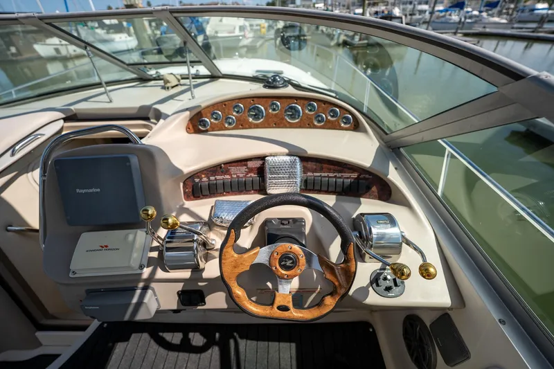 Slide: The Image of Helm of 2000 Sea Ray 340 Sundancer boat with wooden steering wheel and navigation equipment. - 12