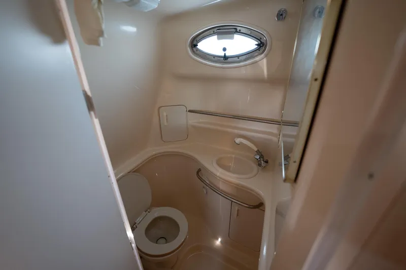 Slide: The Image of Compact bathroom in a 2000 Sea Ray 340 Sundancer yacht, featuring a toilet and sink. - 18